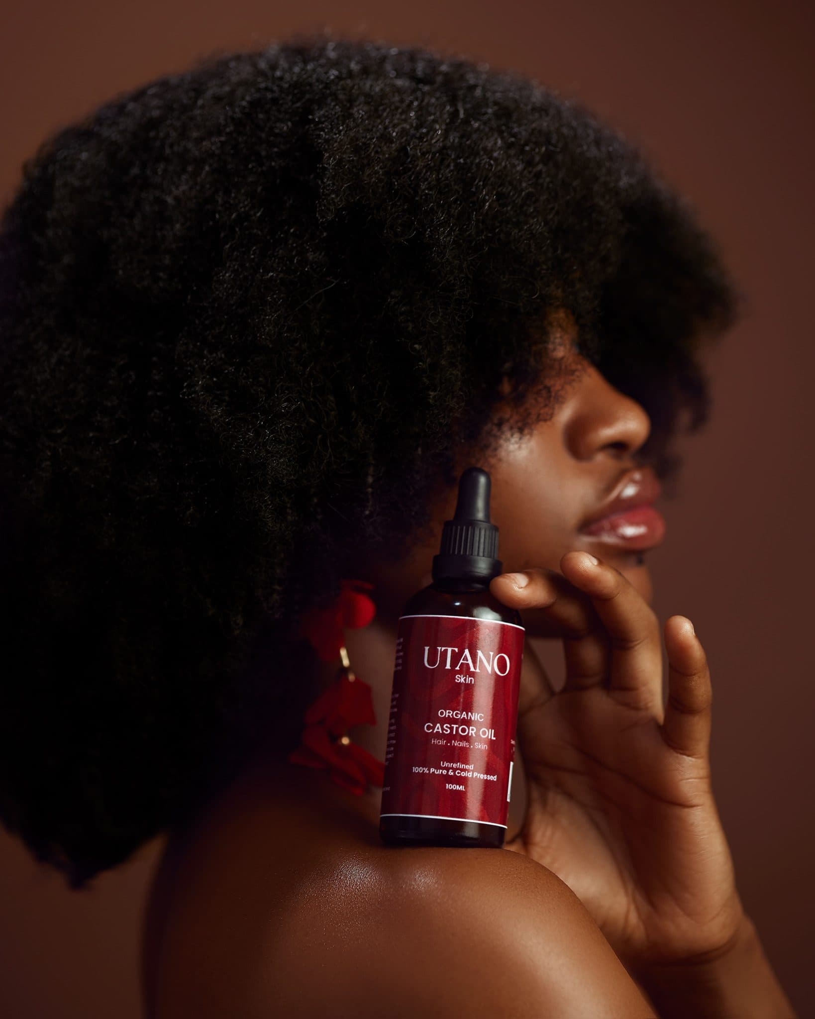 UTANO organic castor oil held to the face in profile