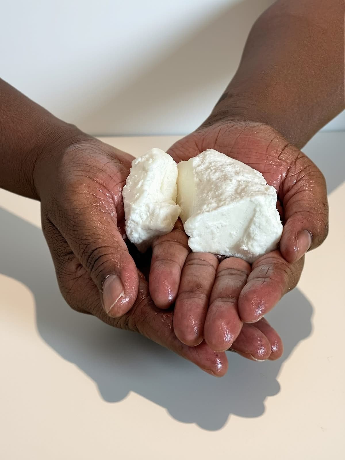 Unrefined shea butter held in open palms
